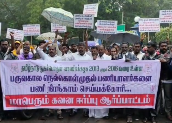 மழையையும் பொருட்படுத்தாமல் நெல் கொள்முதல் நிலைய பருவ கால பணியாளர்கள் பணி வலியுறுத்தி ஆர்ப்பாட்டம்
