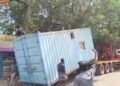 சேதமடைந்த சாலையில் சிக்கிய கண்டெய்னர் லாரி – மரக்கிளையில் மோதி கீழே சரிந்த கன்டெய்னர்