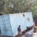 சேதமடைந்த சாலையில் சிக்கிய கண்டெய்னர் லாரி – மரக்கிளையில் மோதி கீழே சரிந்த கன்டெய்னர்